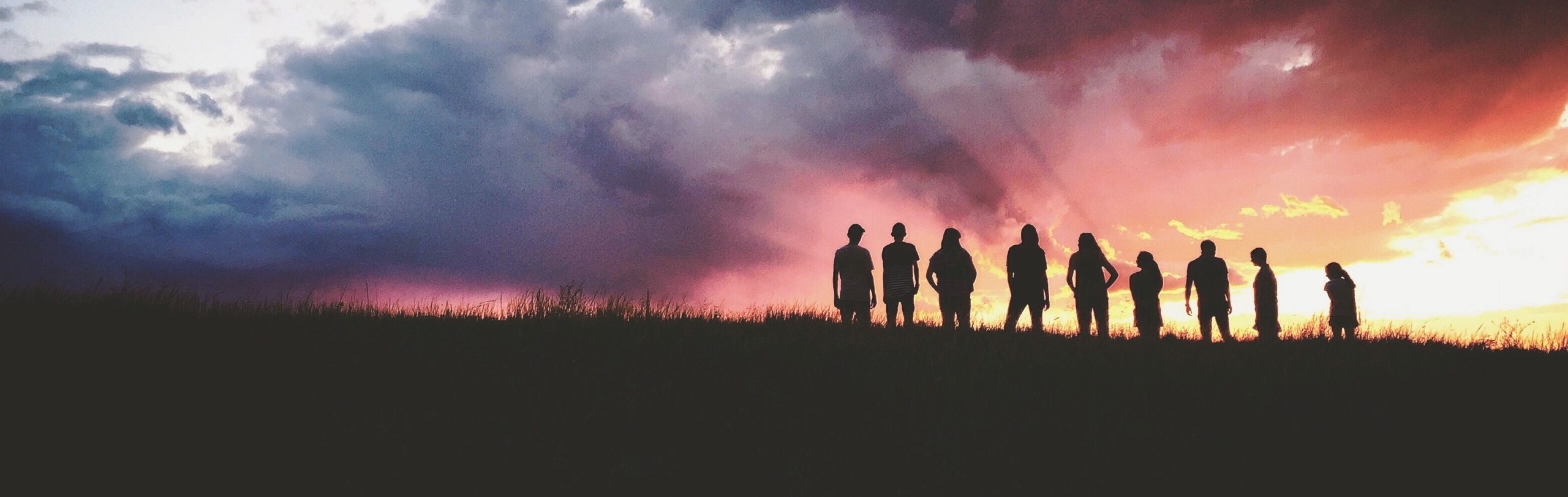 People in a silhouette against a sunset. 